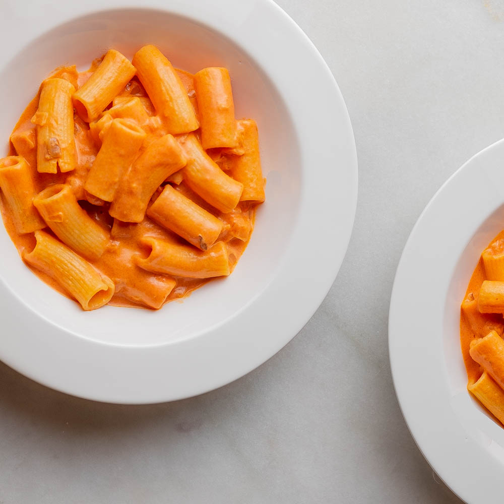 two bowls of rigatoni with vodka sauce